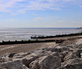 A landscape view of groynes and rock armour on the Eastchurch beach on the Isle of Sheppey in the United Kingdom, where last year the government announced a record $6.2bn investment in flood and coastal defences [Gaia Lamperti/Al Jazeera]