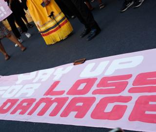 protest sign that says pay up on loss and damage / UNFCC/Flickr
