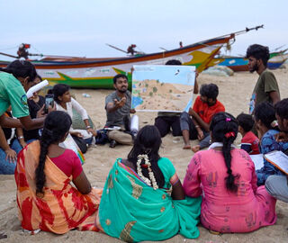 A group of people have learning session on a beach