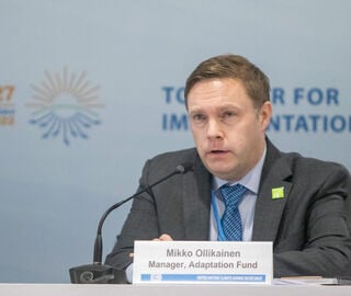 Adaptation Fund Head Mikko Ollikainen sits at conference table speaking