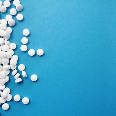 white pills scattered on a blue background