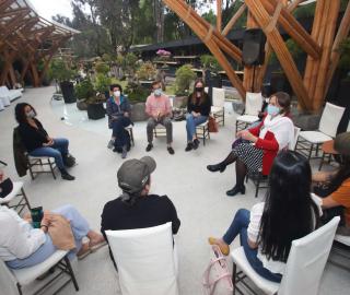 Seated journalists gathered in a circle outdoors