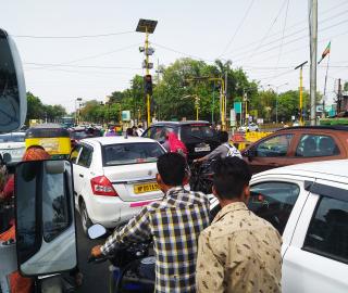 a busy street with cars and two-wheelers in Indore